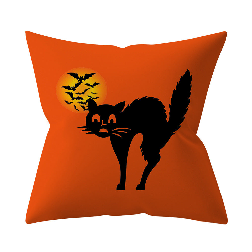 Orange pillow with a black cat and bats design on a white background