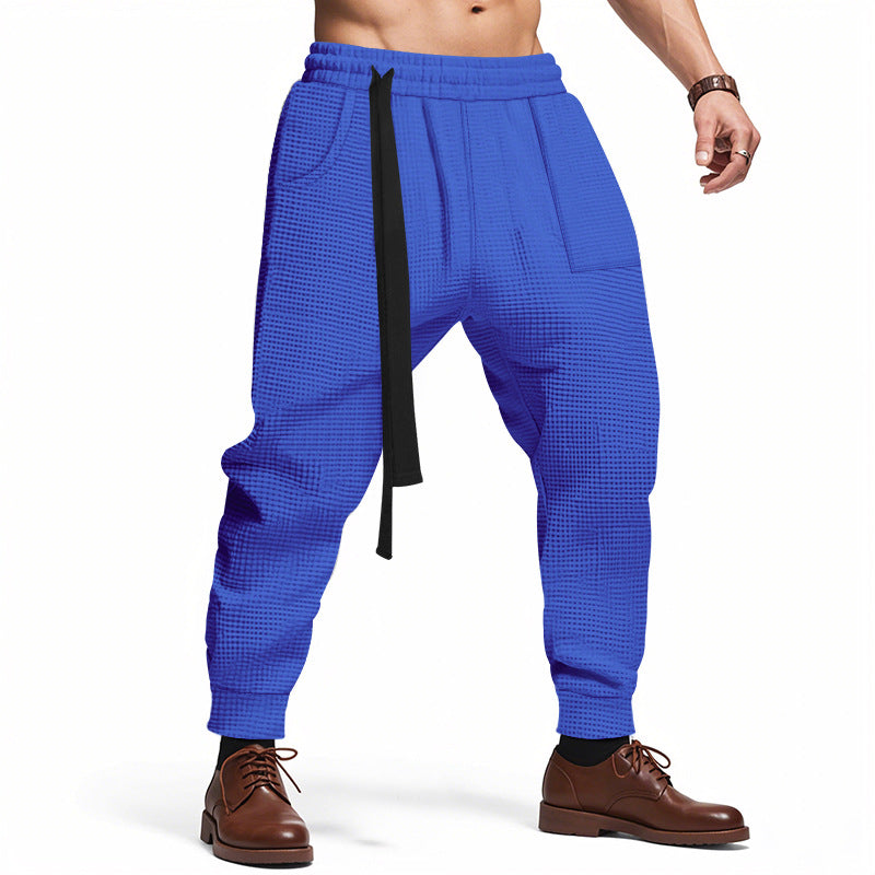 Blue checkered pants with a black belt worn by a person on a white background
