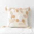Decorative pillow with tassels on a textured white background