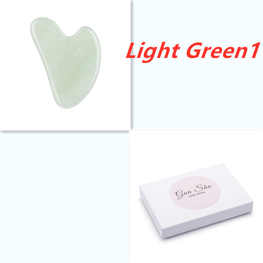 Light green gua sha tool with packaging on a white background