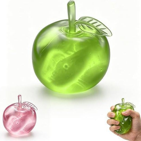 A translucent green apple-shaped squishy toy is shown on a white background, with a smaller pink version at lower left and a hand holding a green version at lower right.