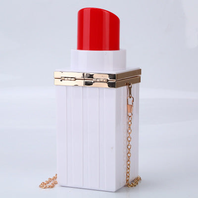 White lipstick case with red cap and gold chain on a light gray background