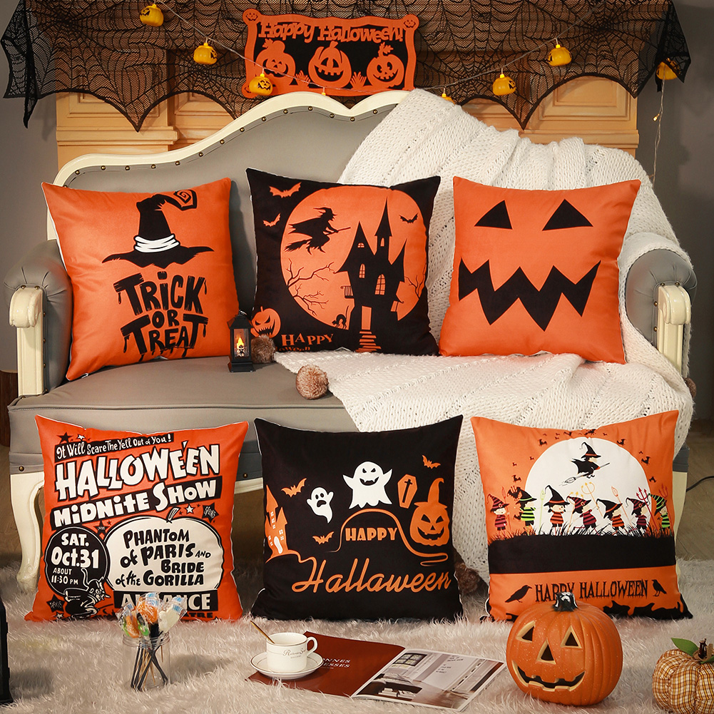 Halloween-themed decorative pillows on a sofa with pumpkins and spider webs.