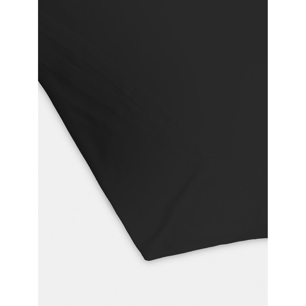 A close-up of a solid black fabric, likely a t-shirt or garment, folded diagonally to show its texture and drape against a plain white background.
