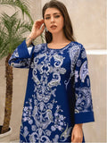 Woman wearing a blue embroidered dress with a palm tree in the background