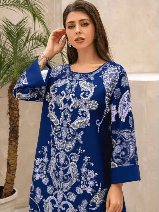 Woman wearing a blue embroidered dress with a palm tree in the background