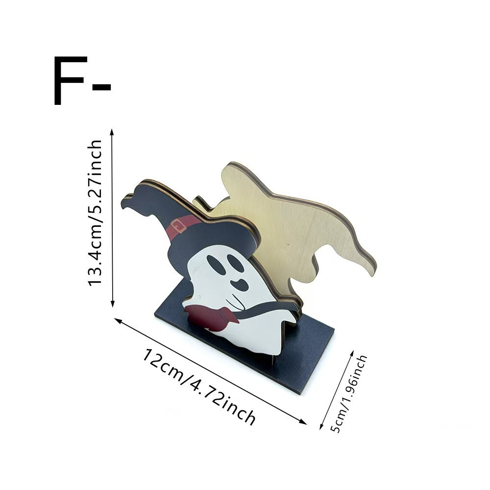 A Halloween-themed wooden cutout of a ghost in a witch hat on a black base, shown with dimension arrows and labels indicating 13.4cm height, 12cm width, and 5cm depth on a white background.
