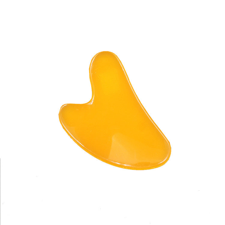 Yellow Gua Sha tool on a white background