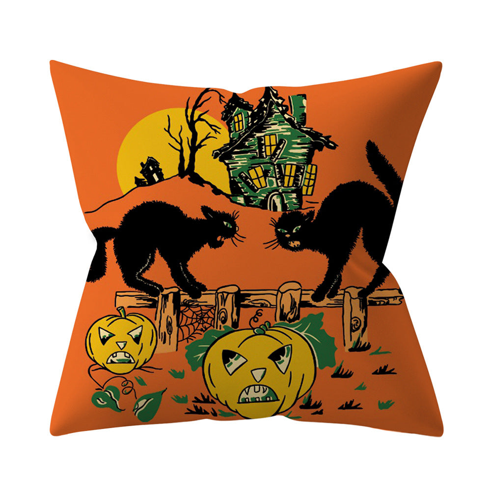 Halloween-themed pillow with pumpkins, cats, and a haunted house on an orange background.