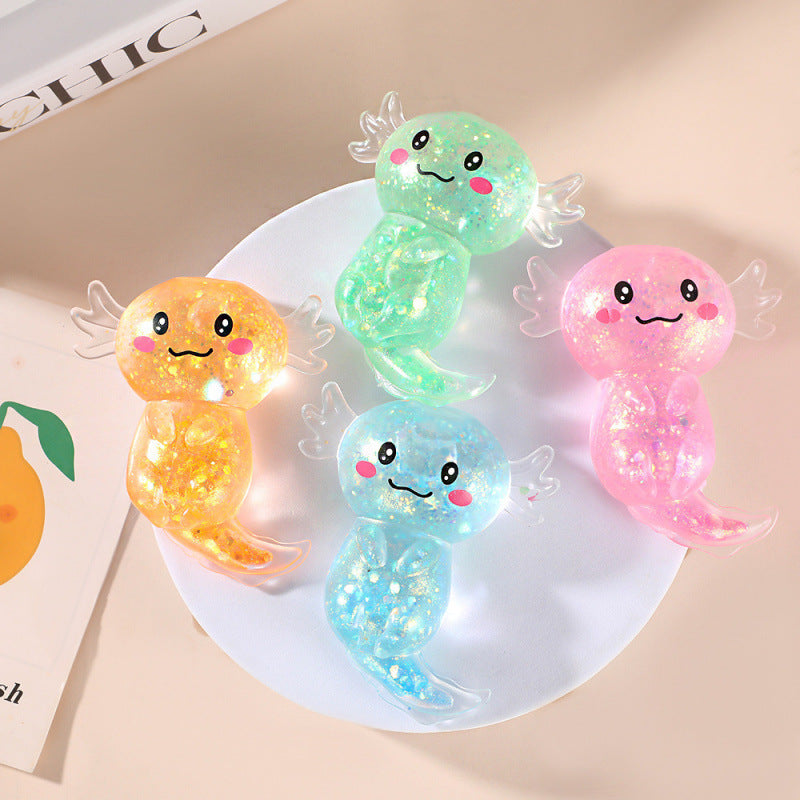 Four colorful, cartoonish squishy toys on a white plate with a magazine in the background.