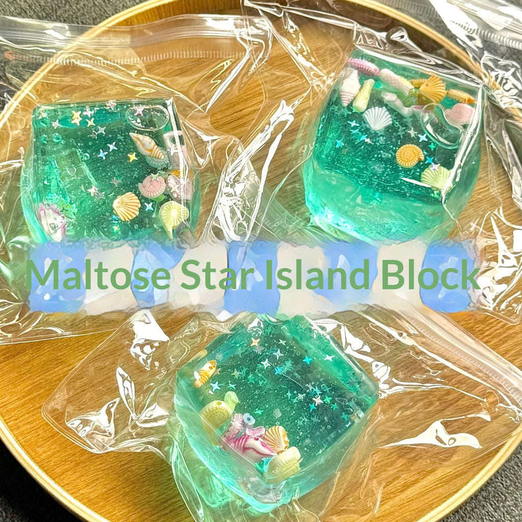 Green maltose star island blocks in clear packaging on a wooden surface