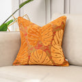 Decorative pillow with leaf pattern on a beige sofa