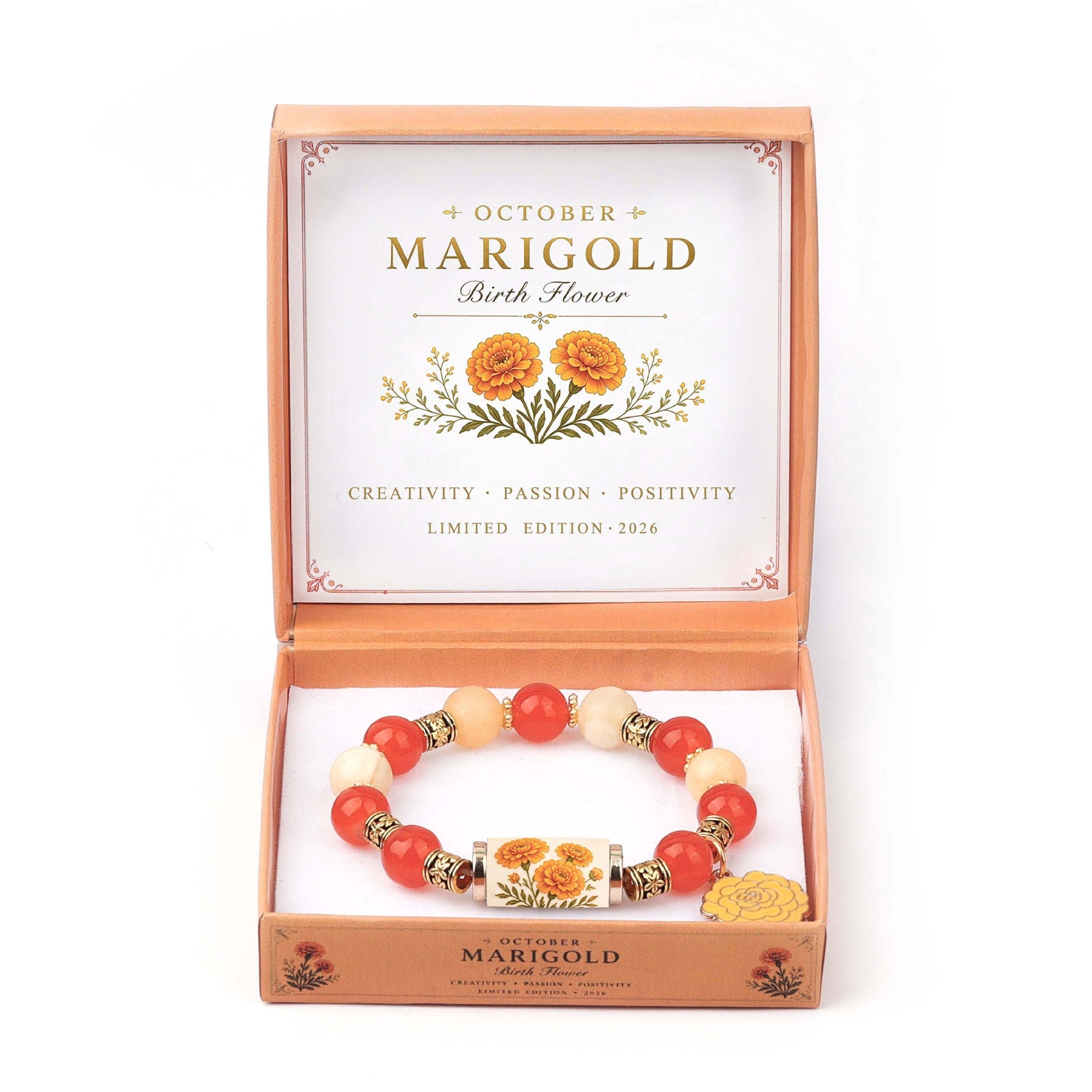 A beaded bracelet displayed inside an open branded gift box. The bracelet has red and cream beads with metallic gold spacer rings and a central charm featuring a flower illustration.