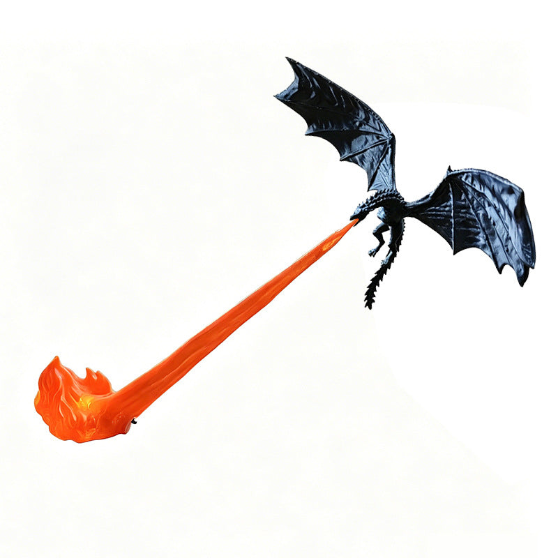 A black dragon toy or decoration with spread wings and a long orange flame-like tail, shown on a plain white background.