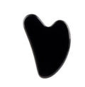 A black, polished, heart-shaped gua sha massage tool on a solid white background.