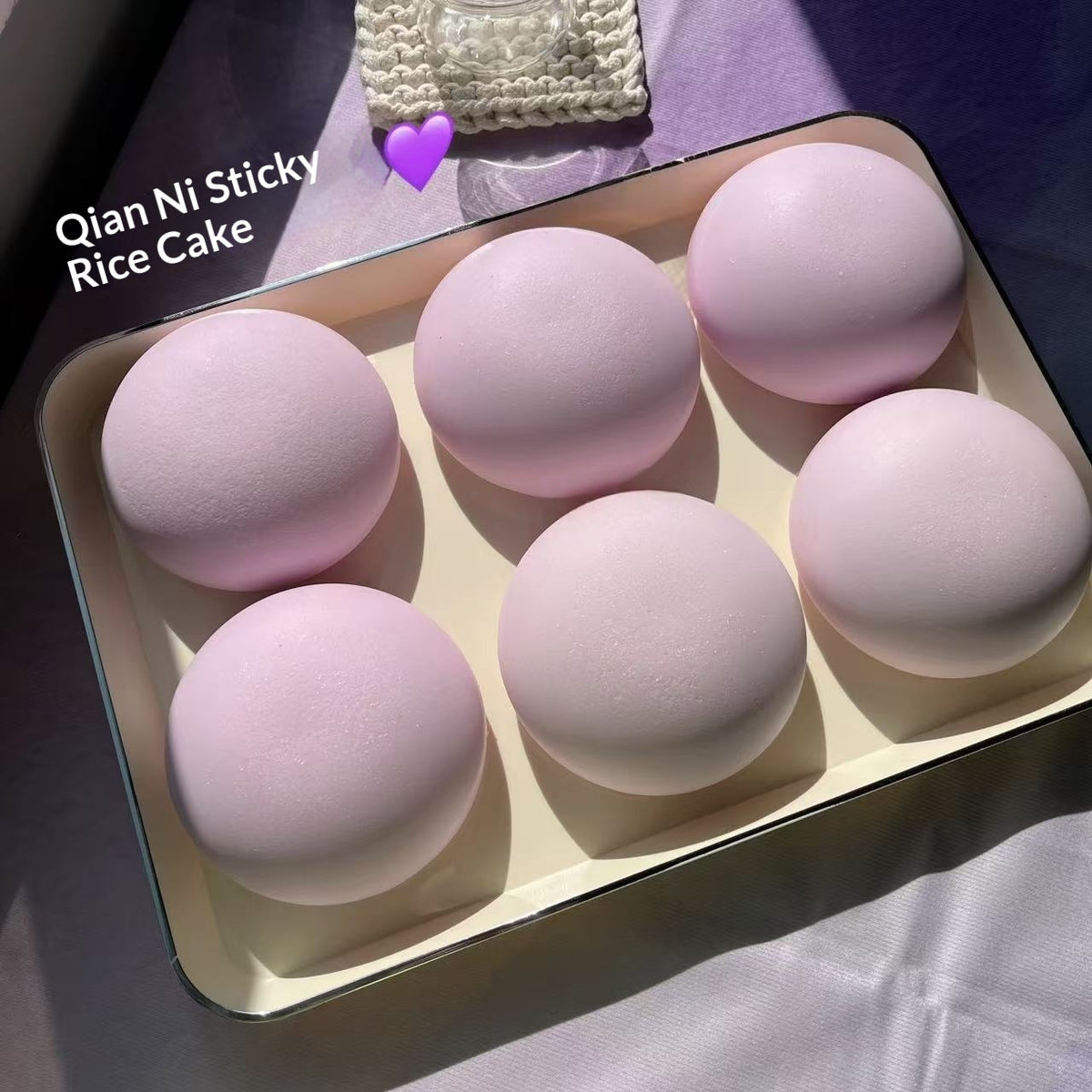Pink rice cakes in a box with 'Qian Ni Sticky Rice Cake' text.