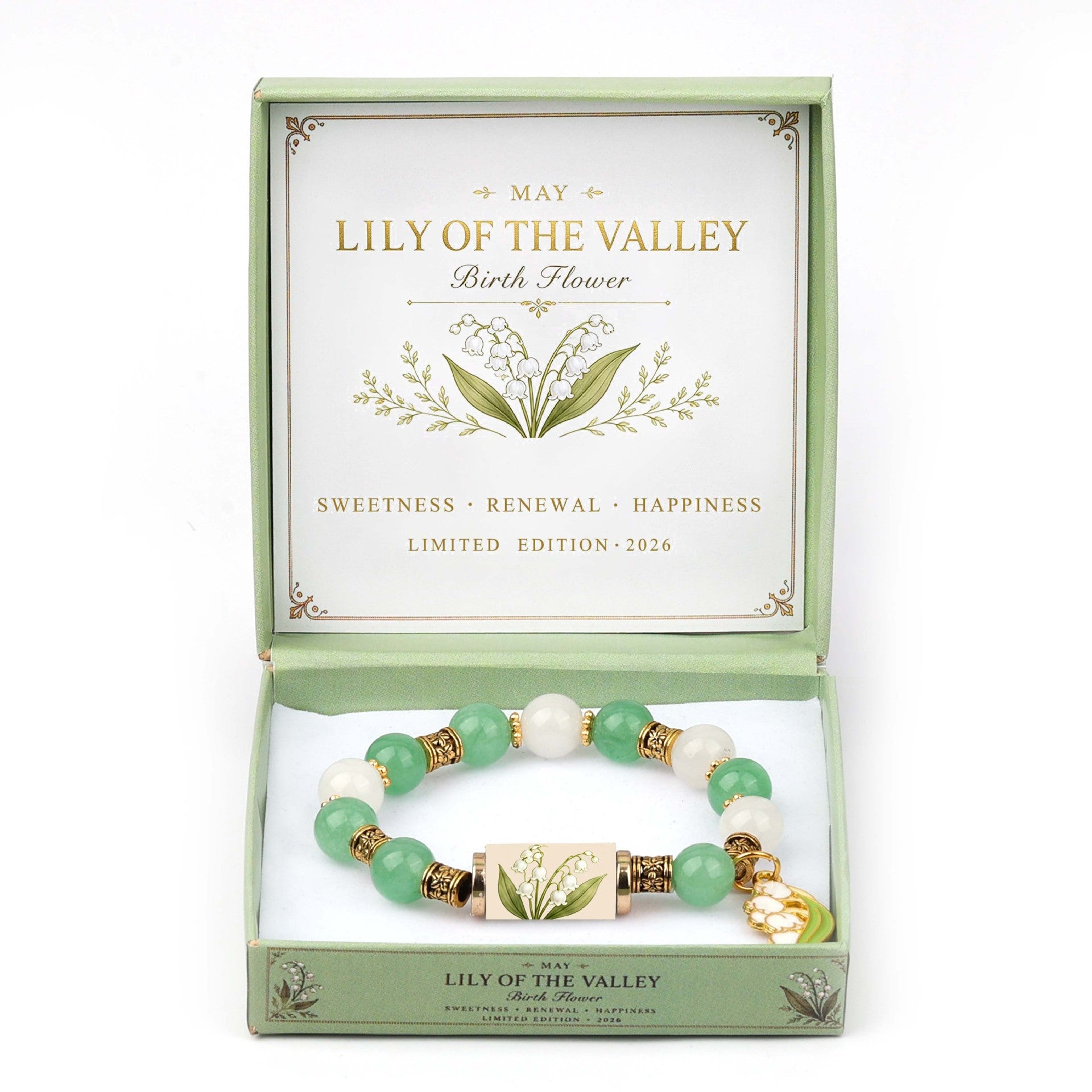 A beaded bracelet presented in an open light green gift box labeled 'Lily of the Valley Birth Flower.' The bracelet has green and white beads with gold-toned spacer details and a central floral charm.