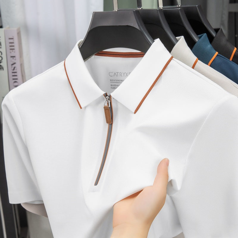 White shirt with brown zipper held by a hand on a blurred background