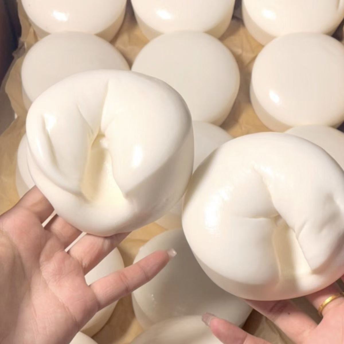 White Yogurt Squishy being held by a hand with a blurred background