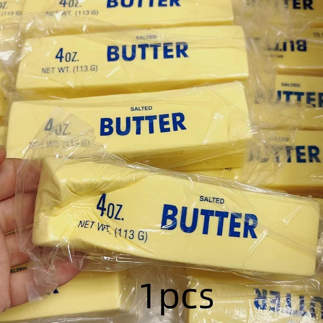 Multiple packages of 4 oz. salted butter squishy with a hand holding one package.