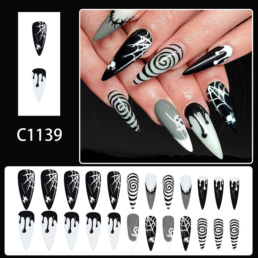 Nail art design with black, white, and gray patterns on nails held in a hand, with a nail art template on the side.