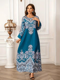 Woman wearing a blue dress with intricate patterns in an elegant room.