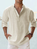 Man wearing a beige shirt with rolled-up sleeves against a blurred background
