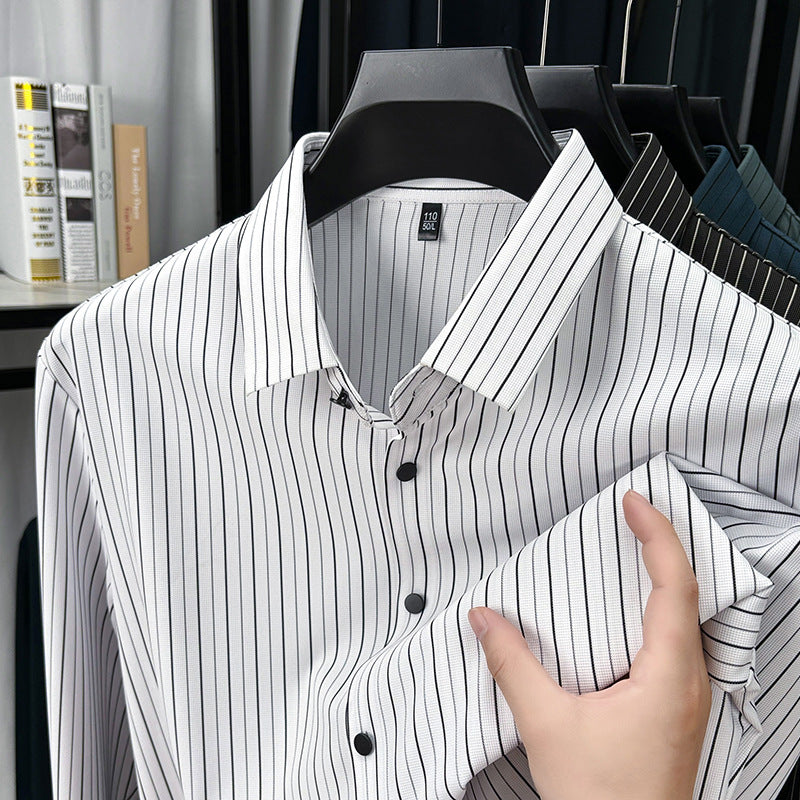 Black and white striped shirt on a hanger with a hand adjusting it, in an indoor setting.