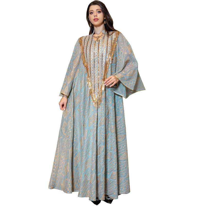 Woman wearing a long, patterned dress with gold accents on a white background