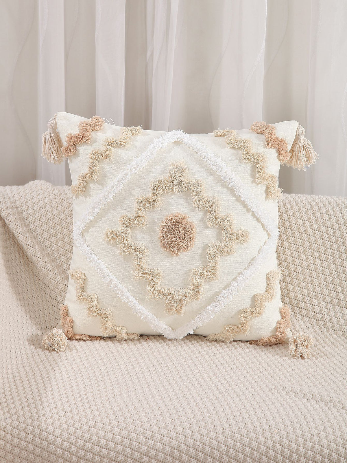 Decorative pillow with intricate patterns on a beige sofa.
