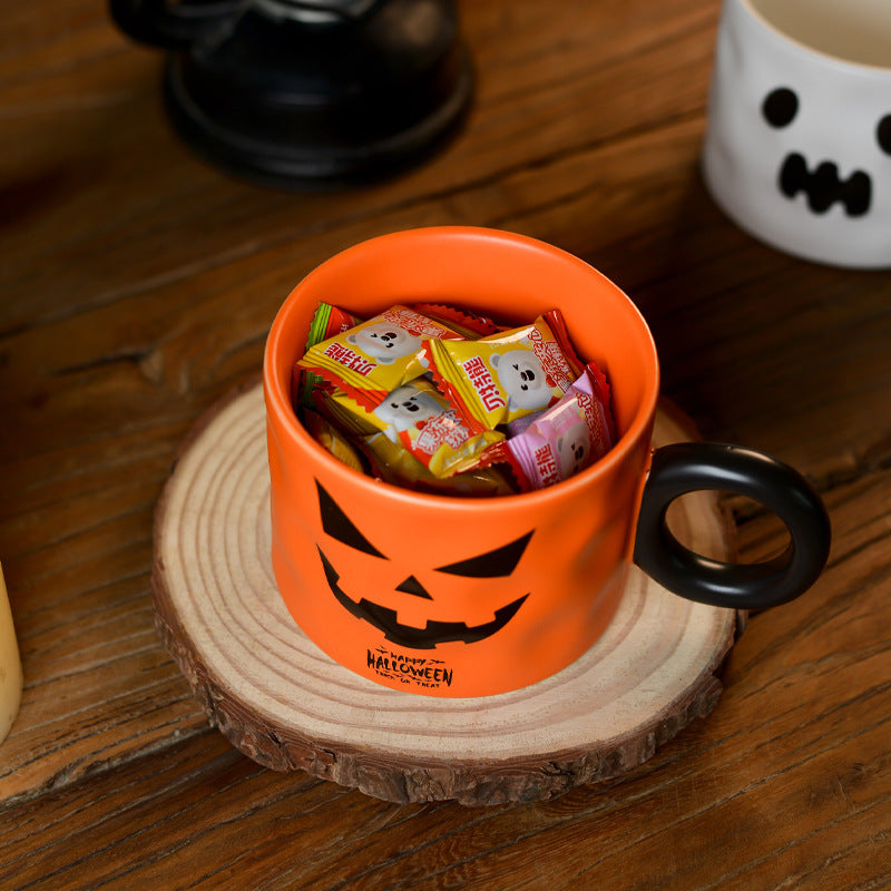 Halloween-themed mug with candies inside mug with white mug on a wooden background