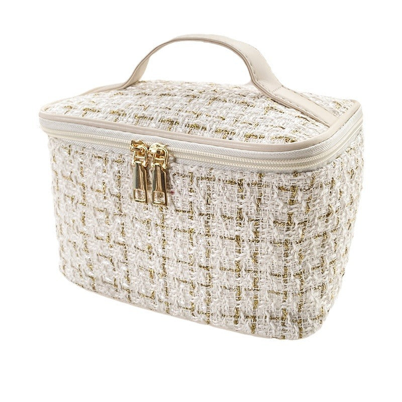 White and gold textured cosmetic bag with gold zipper on a white background