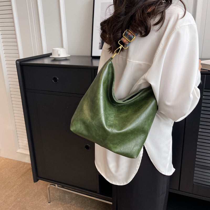 Person holding a green handbag in an indoor setting