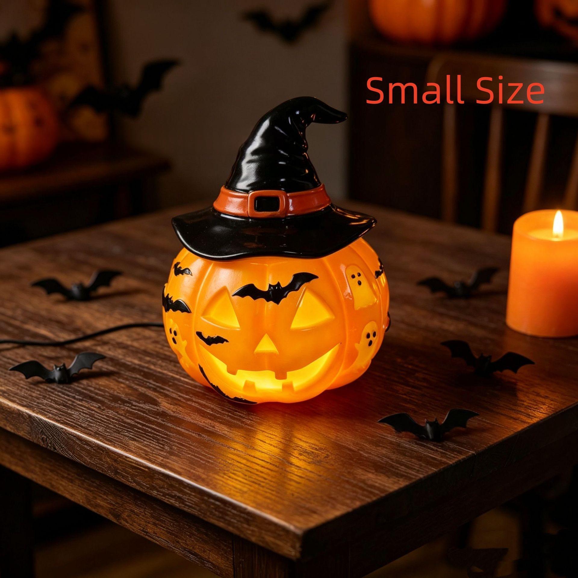 A small Halloween jack-o'-lantern table light with a black witch hat, glowing orange, placed on a wooden table with a lit candle and decorative bats in a dimly lit room. Red text in the upper right reads 'Small Size'.