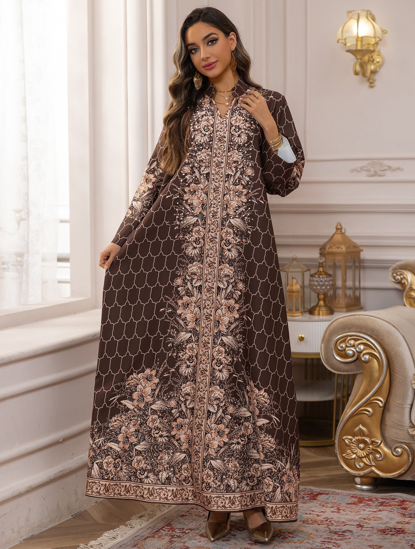 Woman wearing a long, patterned dress in an elegant room with decorative elements.