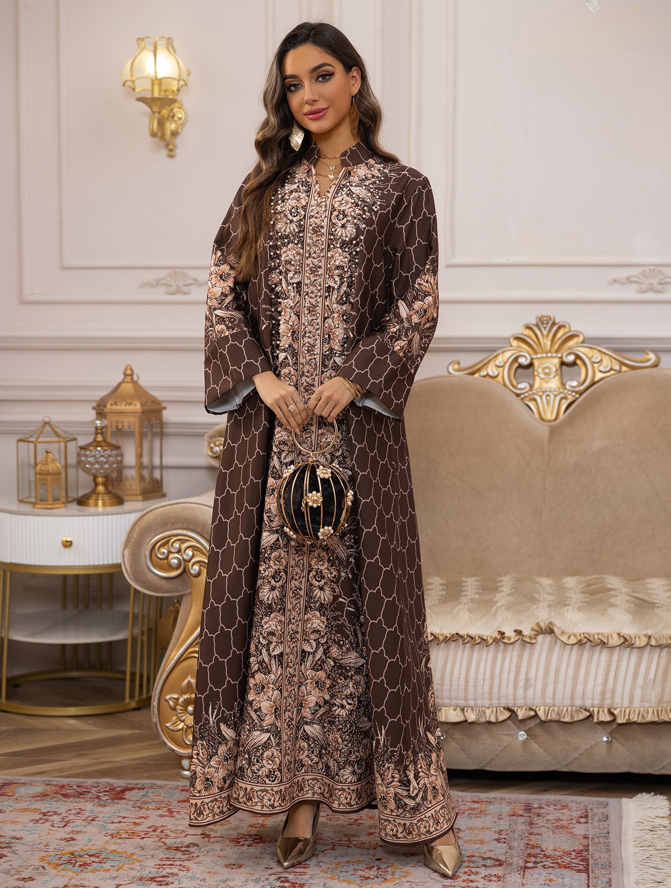Woman in an elegant brown and gold dress standing in a luxurious room with decorative furniture.