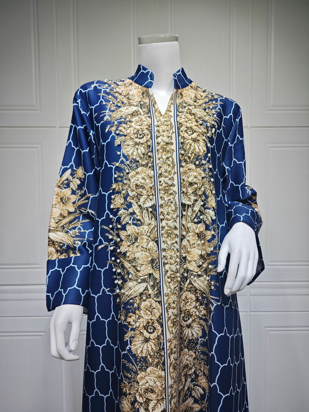 Navy blue and gold patterned coat on a mannequin against a gray background
