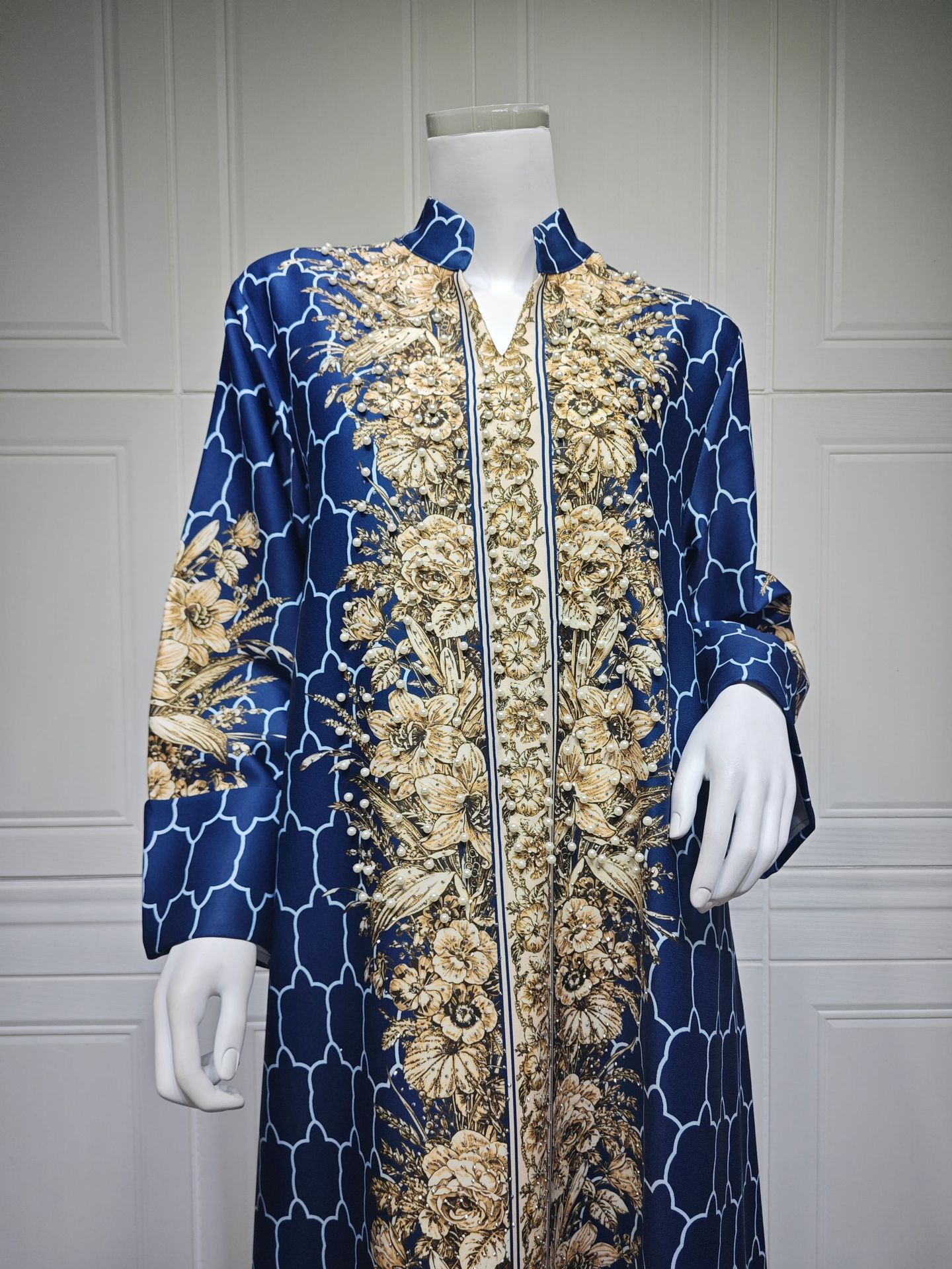 Navy blue and gold patterned coat on a mannequin against a gray background