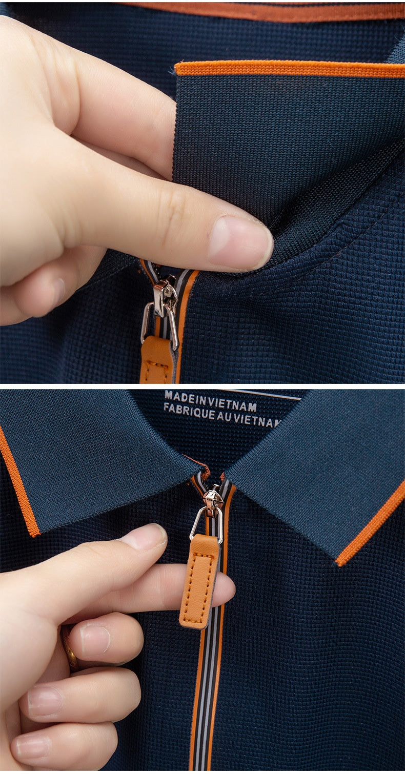 Close-up of a navy blue garment with orange accents, featuring a hand pointing to a brand tag.